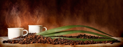 Caffè in tazza, con chicchi sparsi sulla tavola